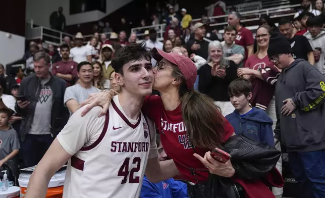 Stanford forward Maxime Raynaud (42) is kissed by his mother Vanessa Raynaud after the team's victory against California in an NCAA college basketball game Saturday, Feb. 22, 2025, in Stanford, Calif. (AP Photo/Godofredo A. Vásquez)