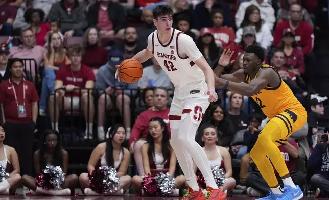 Stanford forward Maxime Raynaud (42) looks for an open teammate while defended by California center Mady Sissoko, right, during the first half of an NCAA college basketball game Saturday, Feb. 22, 2025, in Stanford, Calif. (AP Photo/Godofredo A. Vásquez)