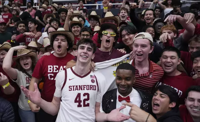 Stanford forward Maxime Raynaud (42) celebrates with fans after the team's victory against California in an NCAA college basketball game Saturday, Feb. 22, 2025, in Stanford, Calif. (AP Photo/Godofredo A. Vásquez)