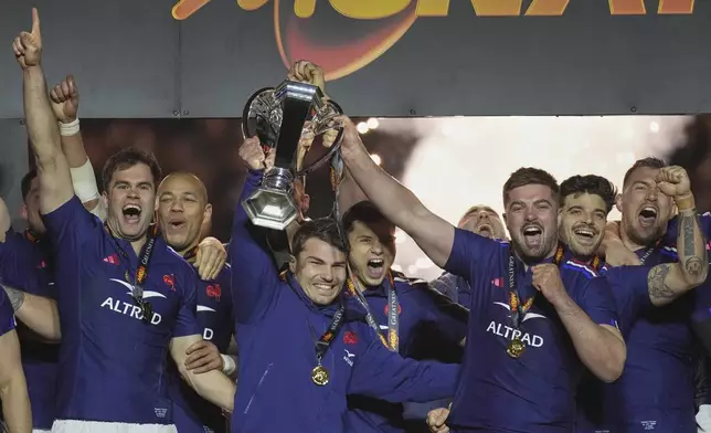The French team players Antoine Dupont, center, and Gregory Alldritt, right, celebrate with the trophy after the Six Nations rugby union match between France and Scotland at the Stade de France in Saint-Denis, outside Paris, Saturday, March 15, 2025. (AP Photo/Christophe Ena)