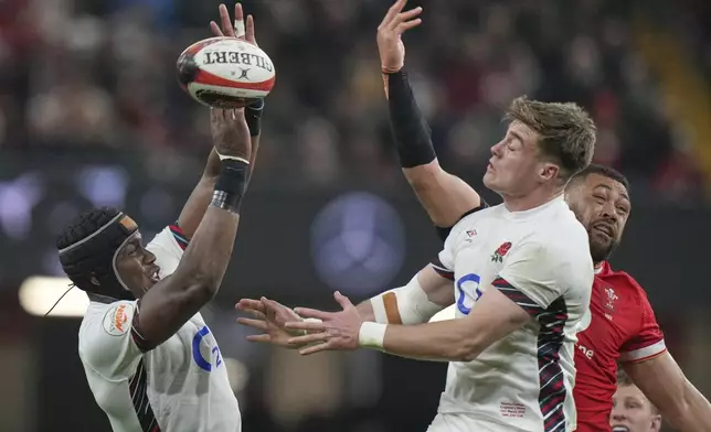 Wales' Taulupe Faletau, right, tips the balls England's Maro Itoje, left, and England's Tommy Freeman try to gather during the Six Nations rugby union match between Wales and England at the Principality Stadium in Cardiff, Wales, Saturday, March 15, 2025. (AP Photo/Alastair Grant)