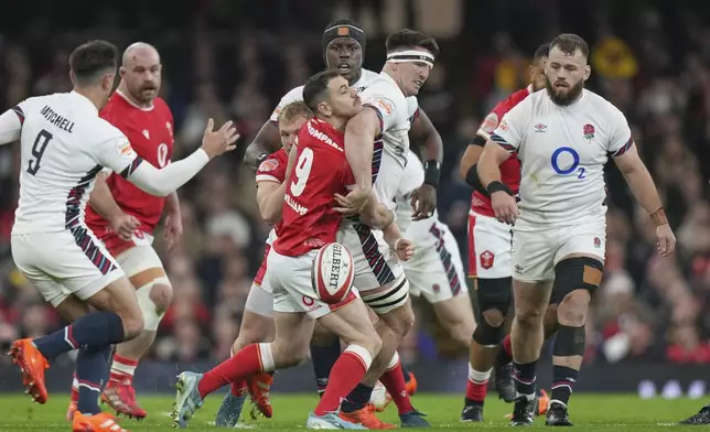 Wales' Tomos Williams , center left, holds onto England's England's England's Tom Curry during the Six Nations rugby union match between Wales and England at the Principality Stadium in Cardiff, Wales, Saturday, March 15, 2025. (AP Photo/Alastair Grant)