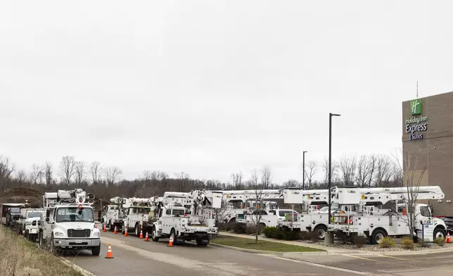 Lineman bucket trucks parked outside the Holliday Inn following a severe storm that passed through in Kalamazoo Twp., Mich., Monday, March 31, 2025. (Joel Bissell/Kalamazoo Gazette via AP)