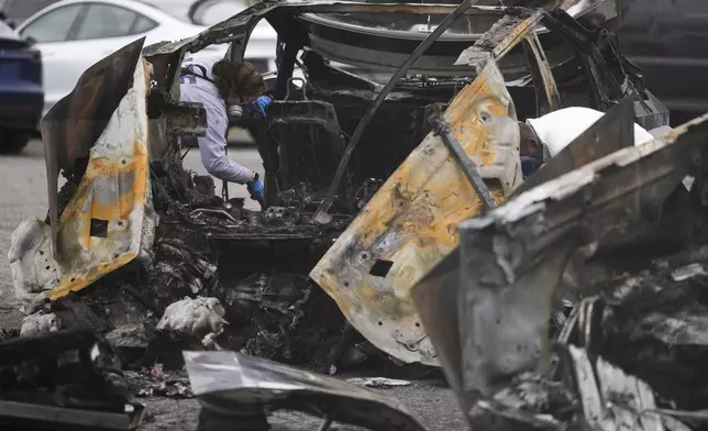 ATF investigators inspect burned Tesla Cybertrucks at a Tesla lot in Seattle, Monday, March 10, 2025. (AP Photo/Lindsey Wasson)