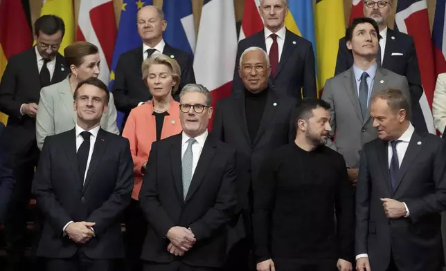 Front row left to right, French President Emmanuel Macron, Britain's Prime Minister Keir Starmer, Ukraine's President Volodymyr Zelenskyy and Poland's Prime Minister Donald Tusk stand with other leaders during a group photo at a summit on Ukraine at Lancaster House in London, Sunday, March 2, 2025. (AP Photo/Christophe Ena, Pool)