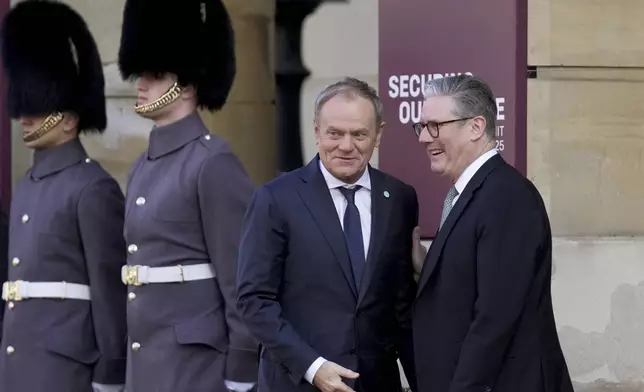 Britain's Prime Minister Keir Starmer, right, greets Poland's Prime Minister Donald Tusk as he arrives for a summit on Ukraine at Lancaster House in London, Sunday, March 2, 2025. (AP Photo/Christophe Ena, Pool)