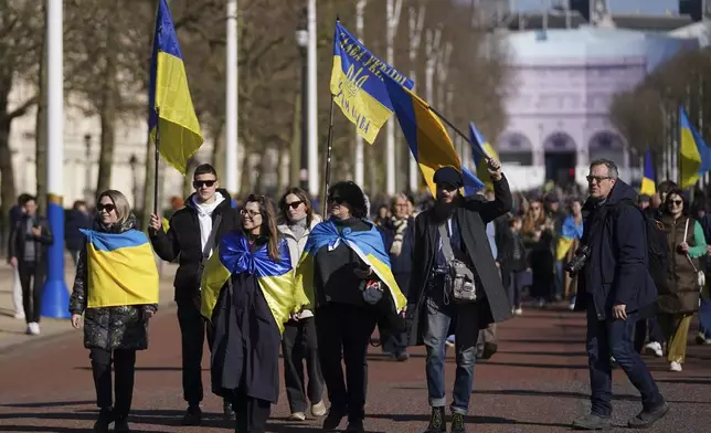 Ukrainian supporters waving flags and banners walk down the Mall as Britain's Prime Minister Keir Starmer chairs a Ukraine Summit at Lancaster House in London, Sunday, March 2, 2025. (AP Photo/Alberto Pezzali)