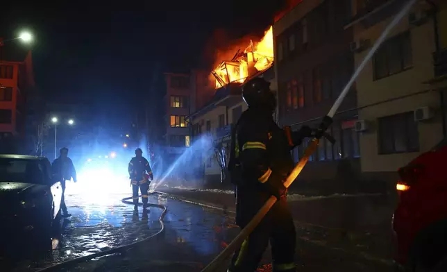 Rescue workers put out a fire from a house hit by a Russian drone strike on a residential neighborhood in Zaporizhzhia, Ukraine, Saturday, March 1, 2025. (AP Photo/Kateryna Klochko)