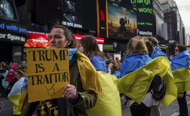 A person holds a sign as members of the New York Ukrainian community and supporters gather in Times Square, Saturday, March 1, 2025 in New York. (AP Photo/Adam Gray)