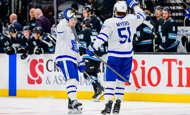 Toronto Maple Leafs right wing Mitch Marner, left, celebrates his game-winning shootout goal with defenseman Philippe Myers (51) during an NHL hockey game against the Utah Hockey Club, Monday, March 10, 2025, in Salt Lake City. (AP Photo/Tyler Tate)