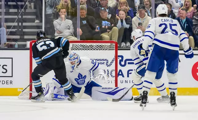 Utah Hockey Club left wing Michael Carcone (53) shoots past Toronto Maple Leafs goaltender Joseph Woll (60) in the second period for the first goal for Utah in an NHL hockey game, Monday, March 10, 2025, in Salt Lake City. (AP Photo/Tyler Tate)