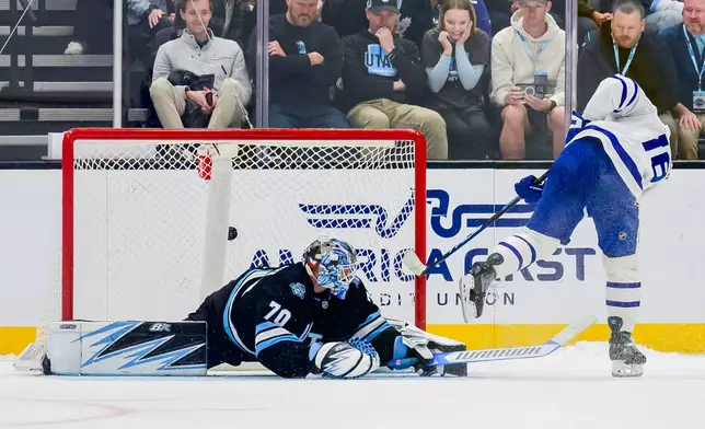 Toronto Maple Leafs right wing Mitch Marner (16) scores the winning goal past Utah Hockey Club goaltender Karel Vejmelka (70) during a shootout in an NHL hockey game Monday, March 10, 2025, in Salt Lake City. (AP Photo/Tyler Tate)