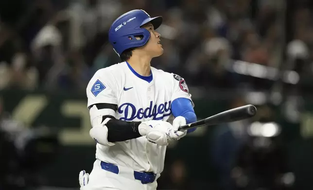 Los Angeles Dodgers' Shohei Ohtani follows through on a solo home run in the fifth inning of an MLB Tokyo Series baseball game against the Chicago Cubs in Tokyo, Japan, Wednesday, March 19, 2025. (AP Photo/Hiro Komae)