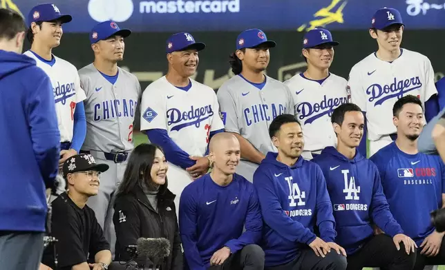Los Angeles Dodgers' Shohei Ohtani, from left rear, Chicago Cubs' Seiya Suzuki, second from top left, Dodgers manager Dave Roberts (30), Cubs' Shota Imanaga, and the Dodgers' Yoshinobu Yamamoto, and Roki Sasaki, right, pose with team staff members for a photo after their MLB Tokyo Series baseball game in Tokyo, Japan, Wednesday, March 19, 2025. (AP Photo/Eugene Hoshiko)