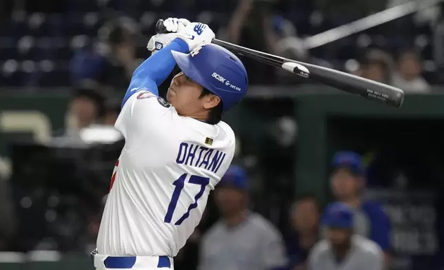 Los Angeles Dodgers' Shohei Ohtani follows through ona fly out to left in the first inning of an MLB Tokyo Series baseball game against the Chicago Cubs in Tokyo, Japan, Wednesday, March 19, 2025. (AP Photo/Eugene Hoshiko)