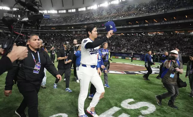 Los Angeles Dodgers' Shohei Ohtani tips his cap as he leaves the field after the team's win against the Chicago Cubs in an MLB Tokyo Series baseball game in Tokyo, Japan, Wednesday, March 19, 2025. (AP Photo/Eugene Hoshiko)