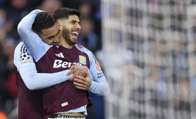 Aston Villa's Marco Asensio, right, celebrates with Aston Villa's Morgan Rogers after scoring his side's third goal during the Champions League round of 16 second leg soccer match between Aston Villa and Club Brugge at the Villa Park stadium in Birmingham, England, Wednesday, March 12, 2025. (AP Photo/Darren Staples)