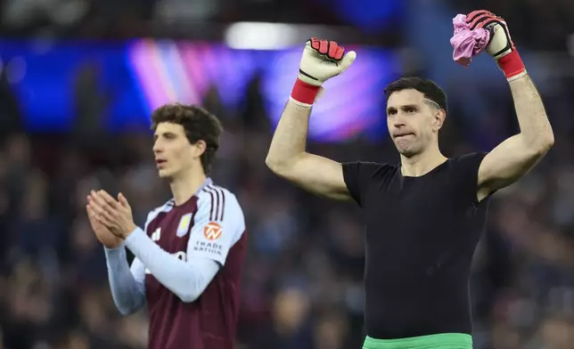 Aston Villa's goalkeeper Emiliano Martinez, right, and Aston Villa's Pau Torres celebrate at the end of the Champions League round of 16 second leg soccer match between Aston Villa and Club Brugge at the Villa Park stadium in Birmingham, England, Wednesday, March 12, 2025. (AP Photo/Darren Staples)