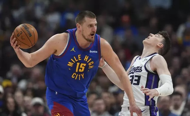 Denver Nuggets center Nikola Jokic, left, drives past Sacramento Kings forward Jake LaRavia in the first half of an NBA basketball game Wednesday, March 5, 2025, in Denver. (AP Photo/David Zalubowski)