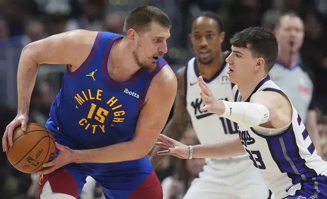 Denver Nuggets center Nikola Jokic, left, looks to pass the ball as Sacramento Kings forwards Jake LaRavia, front right, and DeMar DeRozan defend in the first half of an NBA basketball gme Wednesday, March 5, 2025, in Denver. (AP Photo/David Zalubowski)