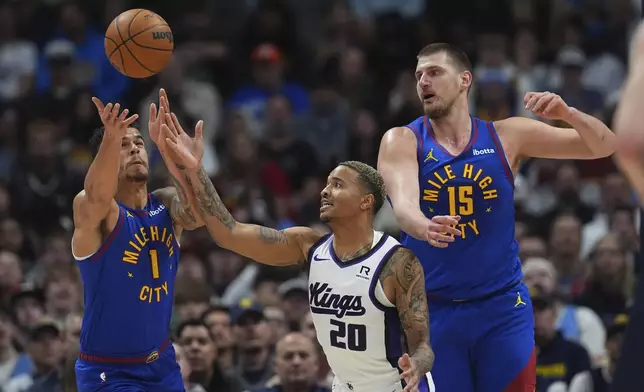 Sacramento Kings guard Markelle Fultz, center, pursues a loose ball with Denver Nuggets forward Michael Porter Jr., left, and center Nikola Jokic in the first half of an NBA basketball gme Wednesday, March 5, 2025, in Denver. (AP Photo/David Zalubowski)