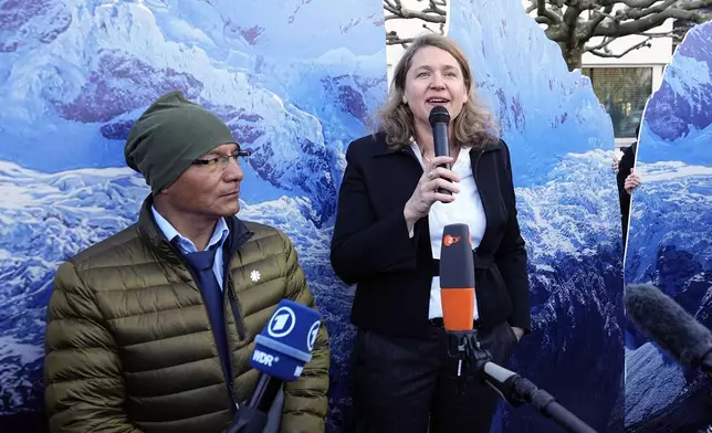 Peruvian farmer Luciano Lliuya, left, listens to lawyer Roda Verheyen at the Higher Regional Court in Hamm, Germany, before a first hearing of his climate damages case against the German energy company RWE for its carbon emissions, which may have been contributing to the melting of a nearby glacier that could flood his home, Monday, March 17, 2025. (AP Photo/Martin Meissner)