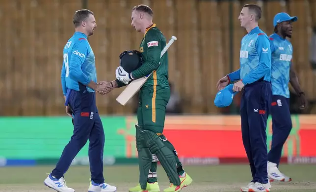 South Africa's Rassie van der Dussen, center, shakes hand with England's Jos Buttler, left, on the end of the ICC Champions Trophy cricket match between England and South Africa, in Karachi, Pakistan Saturday, March 1, 2025. (AP Photo/Anjum Naveed)