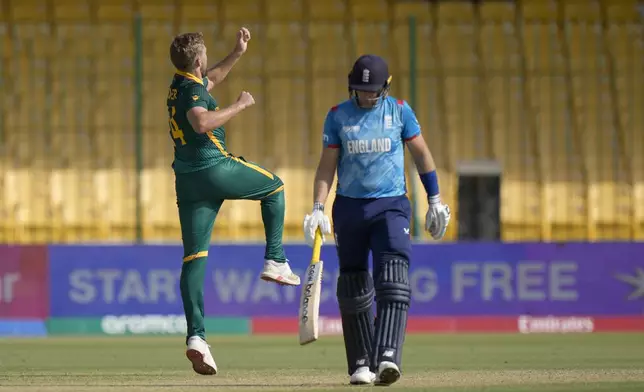 South Africa's Wiaan Mulder, left, celebrates after taking the wicket of England's Joe Root, right, during the ICC Champions Trophy cricket match between England and South Africa, in Karachi, Pakistan Saturday, March 1, 2025. (AP Photo/Anjum Naveed)