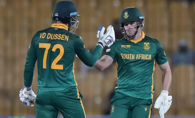 South Africa's David Miller, right, celebrates with Rassie van der Dussen after playing winning shot during the ICC Champions Trophy cricket match between England and South Africa, in Karachi, Pakistan Saturday, March 1, 2025. (AP Photo/Anjum Naveed)