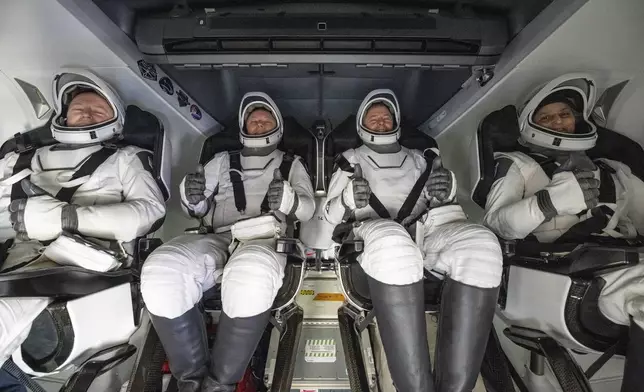 From left, NASA astronaut Butch Wilmore, Russia’s Alexander Gorbunov, and NASA astronauts Nick Hague and Suni Williams sit inside a SpaceX capsule onboard the SpaceX recovery ship Megan after landing in the water off the coast of Florida, Tuesday, March 18, 2025. (Keegan Barber/NASA via AP)