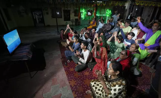Villagers cheer while watching a NASA live stream as they gather to pray for the safe return of NASA astronaut Suni Williams, also known as Sunita Williams, from the International Space Station (ISS), at a temple in her ancestral village Jhulasan in Mehsana district of Gujarat state, India, Wednesday, March 19, 2025. (AP Photo/Ajit Solanki)