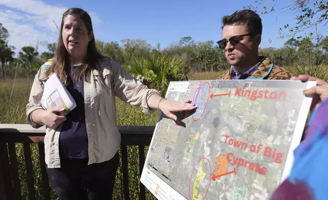 Amber Crooks, environmental policy manager with the Conservancy of Southwest Florida, left, and Michael McGrath of the Sierra Club, right, hold a map showing proposed developments at the Panther National Wildlife Refuge in Southwest Florida, Wednesday, Jan. 15, 2025. (AP Photo/Lynne Sladky)