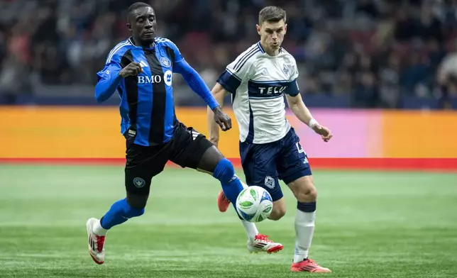 CF Montreal's Prince Owusu, left, and Vancouver Whitecaps' Ranko Veselinovic, right, vie for the during the second half of an MLS soccer match in Vancouver, British Columbia, Saturday, March 8, 2025. (Ethan Cairns/The Canadian Press via AP)