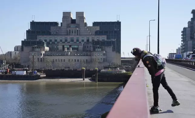 A man stands in front of the headquarters of the Secret Intelligence Service, MI6, in London, Tuesday, March 18, 2025. (AP Photo/Kin Cheung)