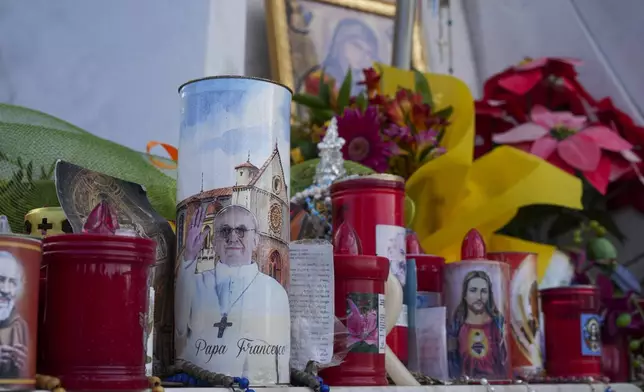 Candles and flowers for Pope Francis are seen in front of the Agostino Gemelli Polyclinic, in Rome, Saturday, March 15, 2025, where the Pontiff is hospitalized since Feb. 14. (AP Photo/Andrew Medichini)