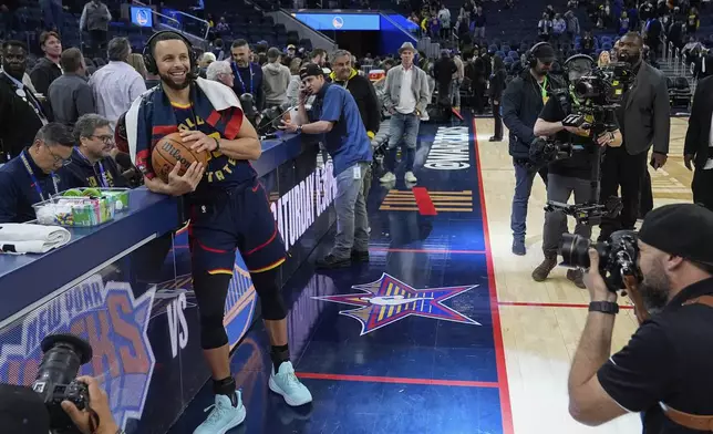 Golden State Warriors guard Stephen Curry, left, is interviewed after the team's victory over the Sacramento Kings in an NBA basketball game Thursday, March 13, 2025, in San Francisco. (AP Photo/Godofredo A. Vásquez)