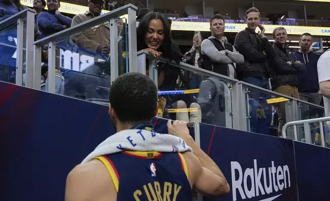 Golden State Warriors guard Stephen Curry, foreground, talks to his wife Ayesha Curry after the team's victory over the Sacramento Kings in an NBA basketball game Thursday, March 13, 2025, in San Francisco. (AP Photo/Godofredo A. Vásquez)