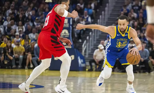 Golden State Warriors guard Stephen Curry (30) drives the ball past Portland Trail Blazers forward Toumani Camara, left, during the first half of an NBA basketball game in San Francisco, Monday, March 10, 2025. (AP Photo/Nic Coury)