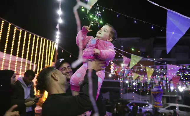 Festive lights are strung between destroyed Palestinian homes for the holy month of Ramadan in Khan Younis, southern Gaza Strip, Friday, Feb. 28, 2025. (AP Photo/Jehad Alshrafi)