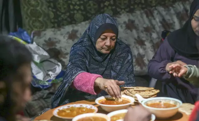 Fatima Al-Absi shares iftar, the fast-breaking meal, with her daughter and grandchildren on the first day of Ramadan in their damaged apartment in Jabaliya, northern Gaza Strip, on Saturday, March 1, 2025. (AP Photo/Jehad Alshrafi)