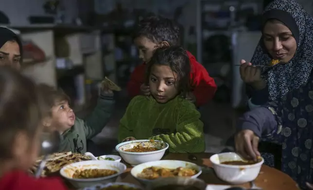 The family of Fatima Al-Absi share Iftar, the fast-breaking meal, on the first day of Ramadan in their damaged apartment in Jabaliya, northern Gaza Strip, on Saturday, March 1, 2025. (AP Photo/Jehad Alshrafi)