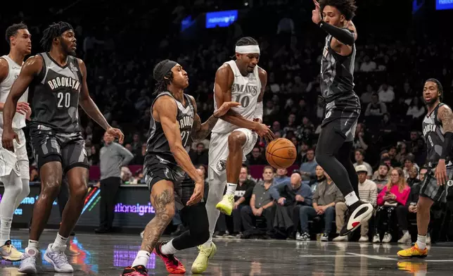 Dallas Mavericks guard Brandon Williams (10) loses control of the ball before regaining it and scoring a two-pointer during the first half of an NBA basketball game against the Brooklyn Nets, Monday, March 24, 2025, in New York. (AP Photo/Angelina Katsanis)
