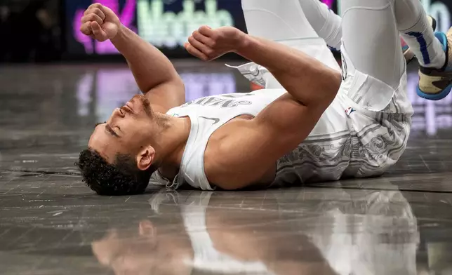 Dallas Mavericks center Dwight Powell (7) celebrates a basket after falling to the ground during the first half of an NBA basketball game against the Brooklyn Nets, Monday, March 24, 2025, in New York. (AP Photo/Angelina Katsanis)