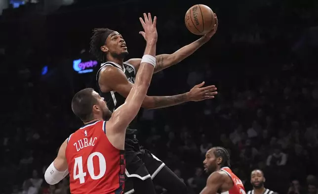 Brooklyn Nets' Nic Claxton (33) drives past LA Clippers' Ivica Zubac (40) during the first half of an NBA basketball game Friday, March 28, 2025, in New York. (AP Photo/Frank Franklin II)