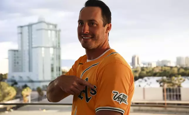 Athletics player Brent Rooker points to a Las Vegas logo on his jersey during a press conference, Friday, March 7, 2025, in Las Vegas. (Wade Vandervort/Las Vegas Sun via AP)