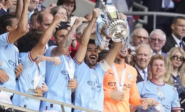 FILE - Manchester City's Ilkay Gundogan, center, holds up the winners trophy as he celebrates with teammates winning the English FA Cup final soccer match between Manchester City and Manchester United at Wembley Stadium in London, Saturday, June 3, 2023. (AP Photo/Dave Thompson, file)