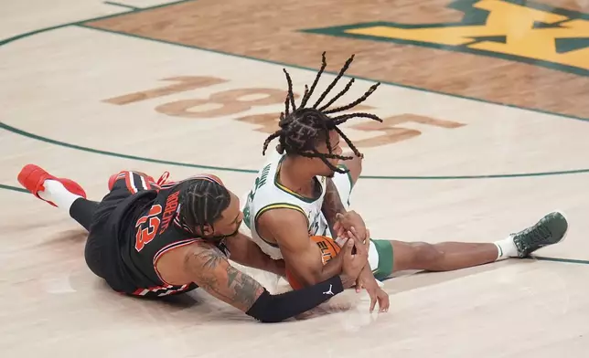 Houston forward J'Wan Roberts, left, and Baylor guard Jayden Nunn compete for a loose ball during the first half of an NCAA college basketball game Saturday, March 8, 2025, in Waco, Texas. (AP Photo/Julio Cortez)