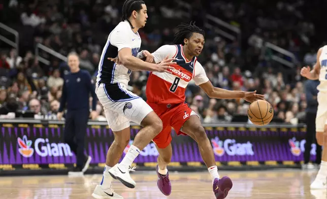 Washington Wizards guard Bub Carrington (8) drives to the basket against Orlando Magic guard Anthony Black, left, during the first half of an NBA basketball game, Friday, March 21, 2025, in Washington. (AP Photo/Nick Wass)