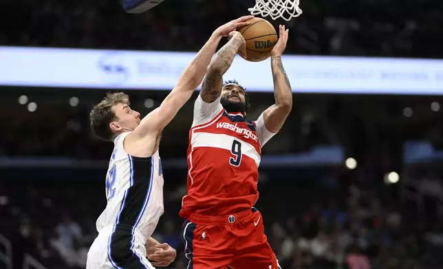 Washington Wizards forward Justin Champagnie (9) goes to the basket against Orlando Magic forward Franz Wagner, left, during the first half of an NBA basketball game, Friday, March 21, 2025, in Washington. (AP Photo/Nick Wass)