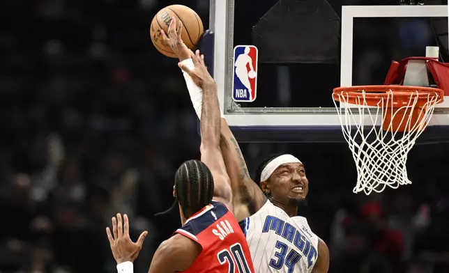 Orlando Magic center Wendell Carter Jr. (34) goes to the basket against Washington Wizards forward Alex Sarr (20) during the first half of an NBA basketball game, Friday, March 21, 2025, in Washington. (AP Photo/Nick Wass)